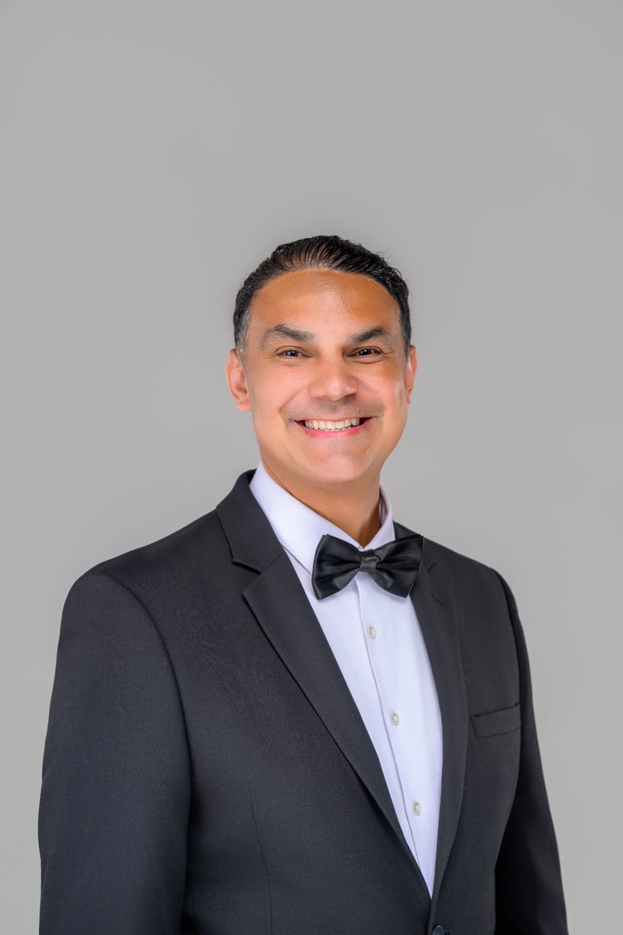 Angel Alba, New England wedding DJ and MC, in a black tuxedo with bow tie