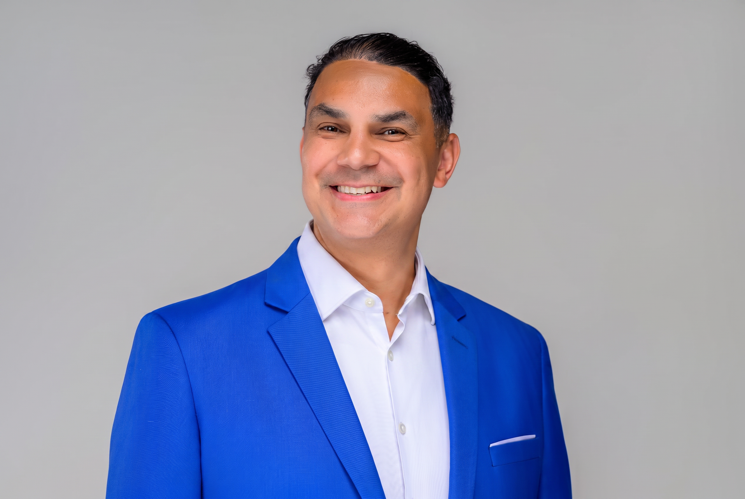 Angel Alba, bilingual corporate event DJ and Master of Ceremonies for galas and conferences in Boston and New England, in a royal blue blazer