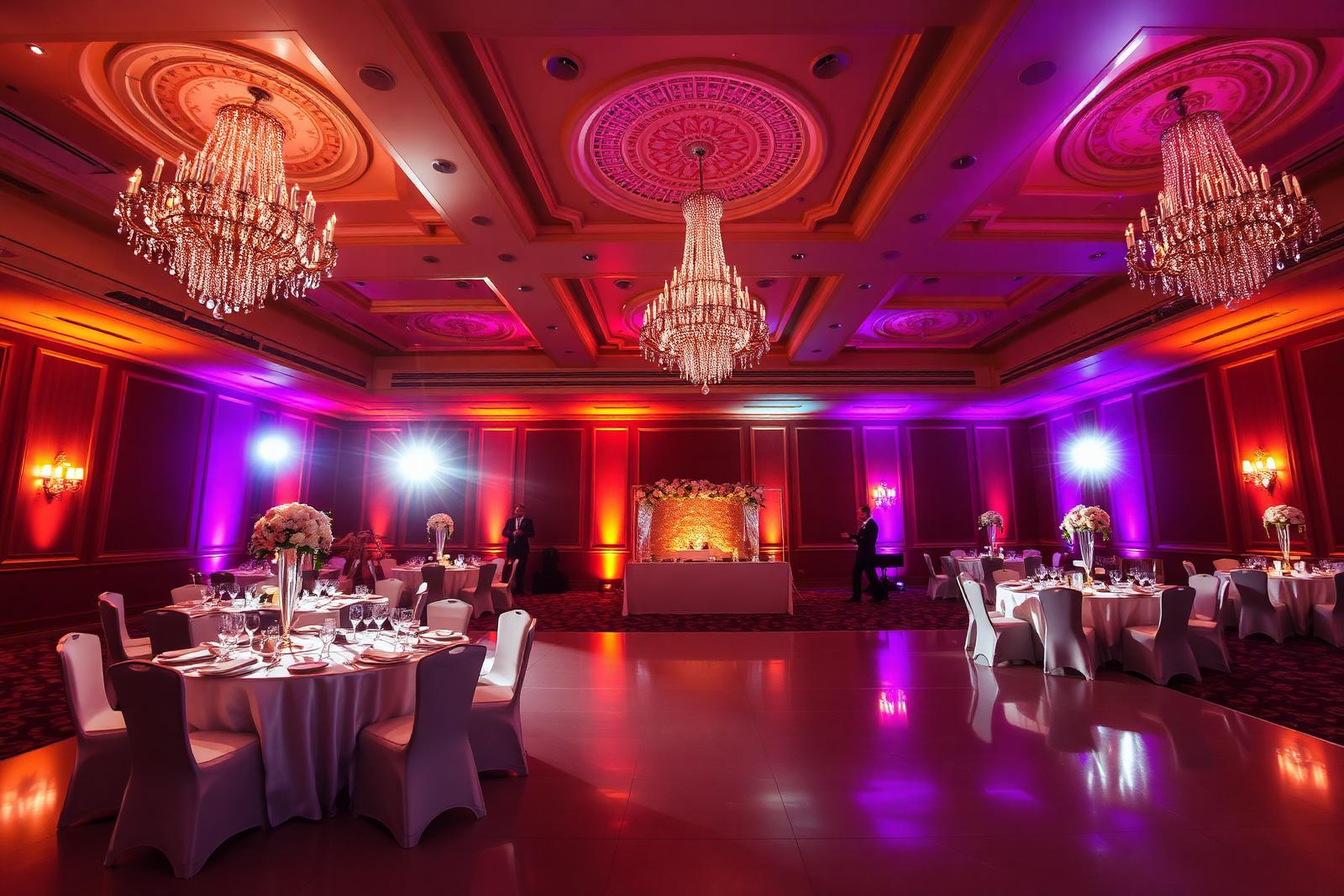 Grand ballroom transformed by warm amber and purple wireless LED uplighting