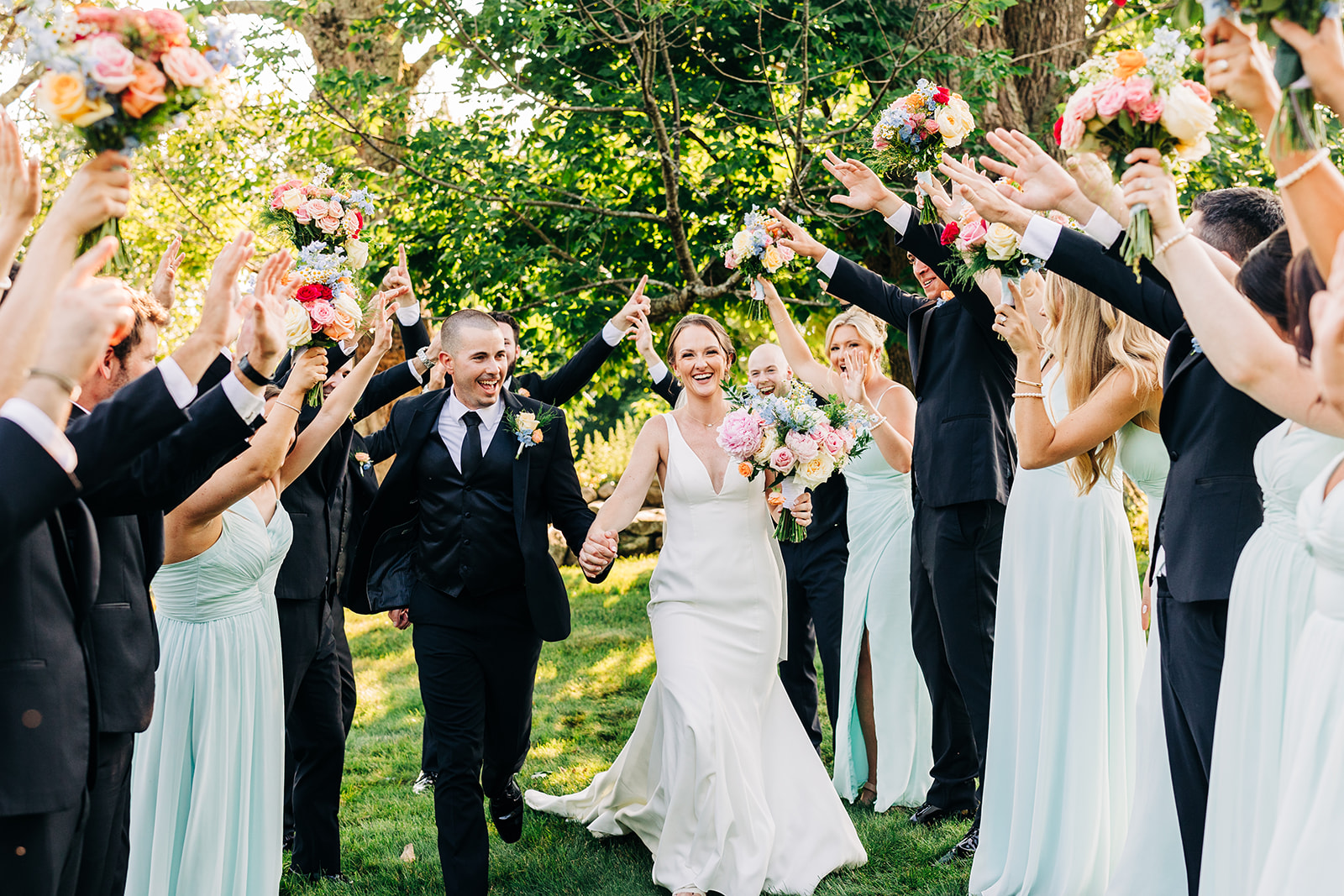 Bride and groom celebrating their recessional through the wedding party